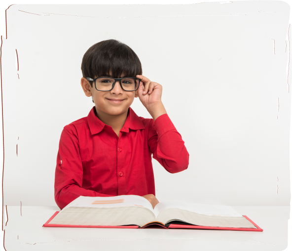 A smart boy is reading a book at his study table.